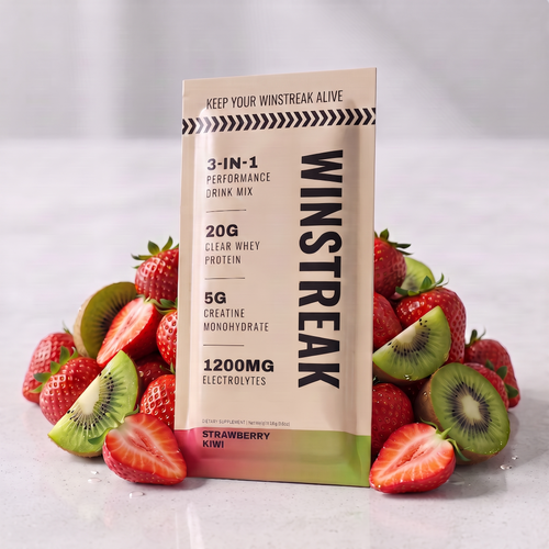 A package of Winstreak 3-in-1 Performance Drink Mix stands upright in the center, surrounded by fresh strawberries and sliced kiwi on a light gray marble surface. The package is cream-colored with black text and a green-to-orange gradient band at the bottom.